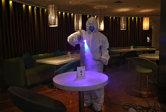 工作人员在印度加尔各答一家酒店的餐馆内为桌子消毒。新华社 资料图